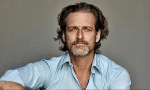 Portret mężczyzny o zielonych oczach i krótko przystrzyżonej brodzie, ubranego w błękitną koszulę. To Alexi Lubomirski.
