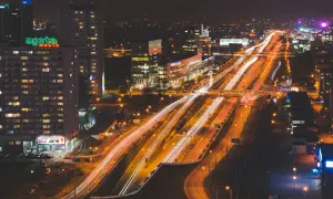 Rozświetlone autostrady i budynki tworzą dynamiczny obraz miasta nocą.