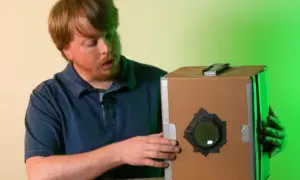 Mężczyzna pokazuje, jak zrobić camera obscura z kartonu.