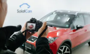 Osoba robi zdjecie z auta, czerwonego SUV-a marki Seat, na ekranie aparatu widać podgląd.