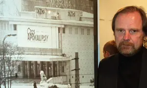 Chris Niedenthal obok plakatu filmu "Czas Apokalipsy" z kinem Moskwa w tle.