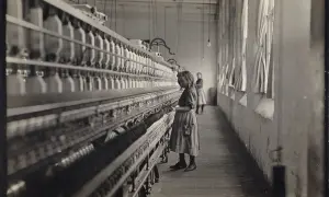 Dziewczynka pracuje przy maszynie w fabryce, jak na zdjęciach Lewis Hine. W tle widać inną pracownicę.
