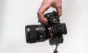 Dłoń trzyma aparat Sony z obiektywem 35 mm f/1.4. Idealny do portretów i krajobrazów, ten obiektyw 35 mm do czego służy?