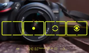 Aparat fotograficzny z zaznaczonymi polami kadrowania i wskaźnikami pomiaru światła.