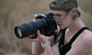 Kobieta w czapce z daszkiem celuje obiektywem aparatu Nikon Z, gotowa uchwycić chwilę. Czy to jej rywal Nikon?