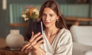 Kobieta robi selfie w lustrze, ale jej twarz jest zasłonięta przez telefon.