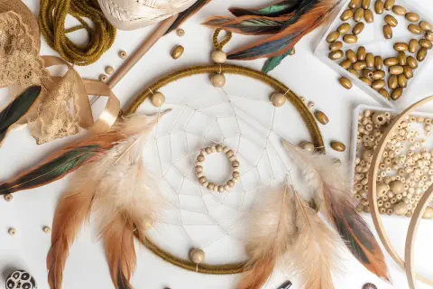 Łapacze snów, pióra, koraliki i koronki tworzą inspirującą sesję boho.