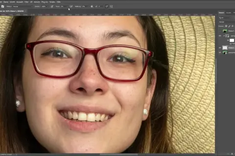 Jak usunąć odbicie w okularach na zdjęciu? Na ekranie widać program do edycji grafiki, gdzie młoda kobieta w okularach jest w trakcie retuszu.