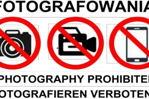 Zakaz fotografowania obiektów wojskowych. Na znaku widać przekreślony aparat, kamerę i telefon.