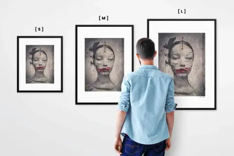 Mężczyzna ogląda trzy obrazy Ewy Ćwikły. Na każdym z nich widnieje surrealistyczny portret kobiety z motylami i czerwonymi ustami.