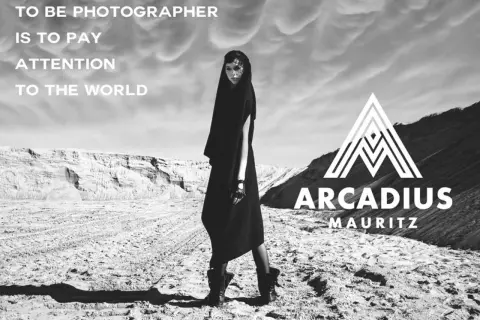 Modelka w czarnej kreacji na pustkowiu, z logo Arcadius Mauritz. "Być fotografem to zwracać uwagę na świat.