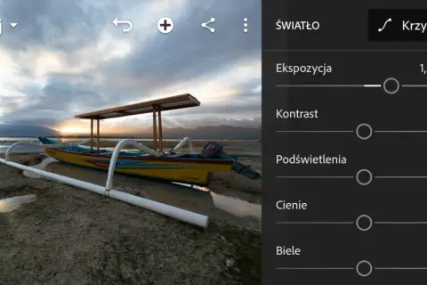 Łódź na plaży podczas zachodu słońca, w trakcie obróbki raw. Widoczne suwaki ekspozycji, kontrastu, podświetleń, cieni i bieli.