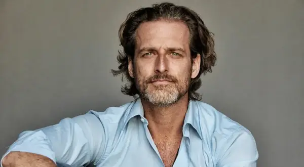 Portret mężczyzny o zielonych oczach i krótko przystrzyżonej brodzie, ubranego w błękitną koszulę. To Alexi Lubomirski.