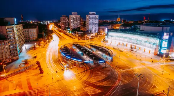 Nocne miasto z widokiem na pętlę tramwajową i dworzec, uchwycone obiektywem kitowym.