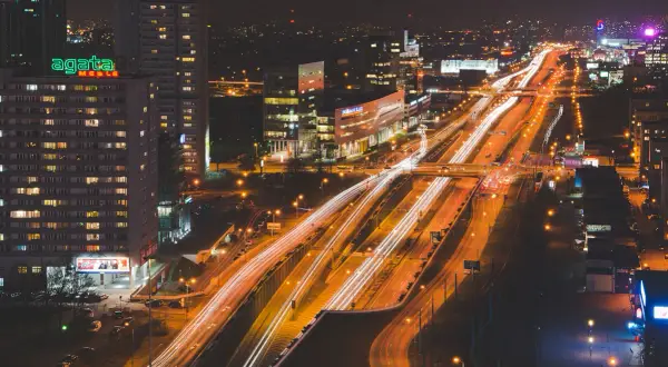 Rozświetlone autostrady i budynki tworzą dynamiczny obraz miasta nocą.
