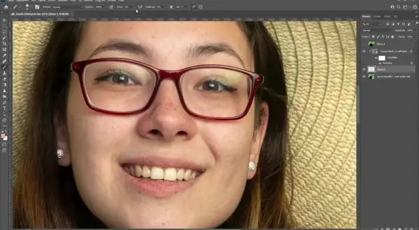 Jak usunąć odbicie w okularach na zdjęciu? Na ekranie widać program do edycji grafiki, gdzie młoda kobieta w okularach jest w trakcie retuszu.