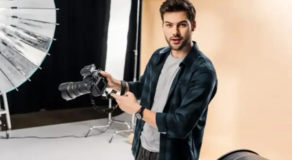 Świetny fotograf z aparatem w studiu. Widać jego pasję i talent.