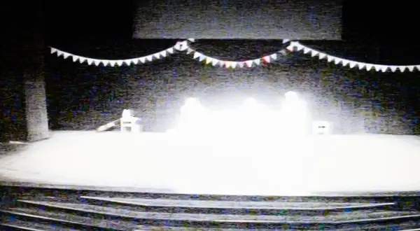 Scena teatralna z girlandą i sylwetkami. Może to być próba spektaklu, w którym gra Bartek Warzecha.