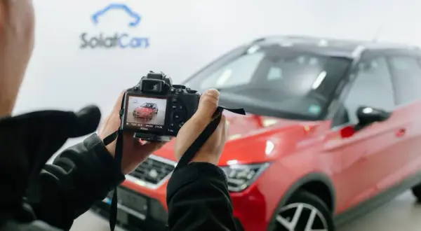 Osoba robi zdjecie z auta, czerwonego SUV-a marki Seat, na ekranie aparatu widać podgląd.