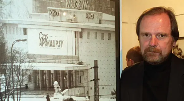 Chris Niedenthal obok plakatu filmu "Czas Apokalipsy" z kinem Moskwa w tle.