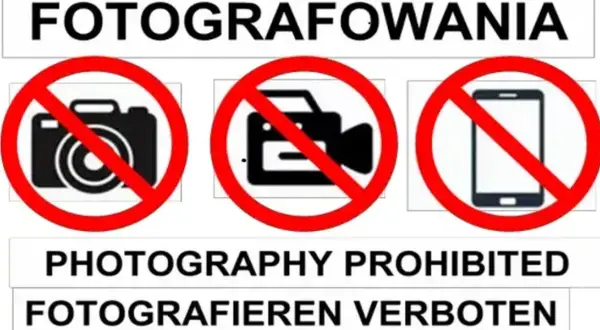 Zakaz fotografowania obiektów wojskowych. Na znaku widać przekreślony aparat, kamerę i telefon.