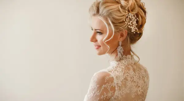 Eleganckie upięcia ślubne z perłami i kryształami, podkreślające urodę panny młodej w koronkowej sukni.