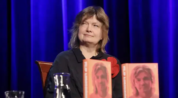Maja Łobodzińska siedzi obok dwóch książek z wizerunkiem Filipa.