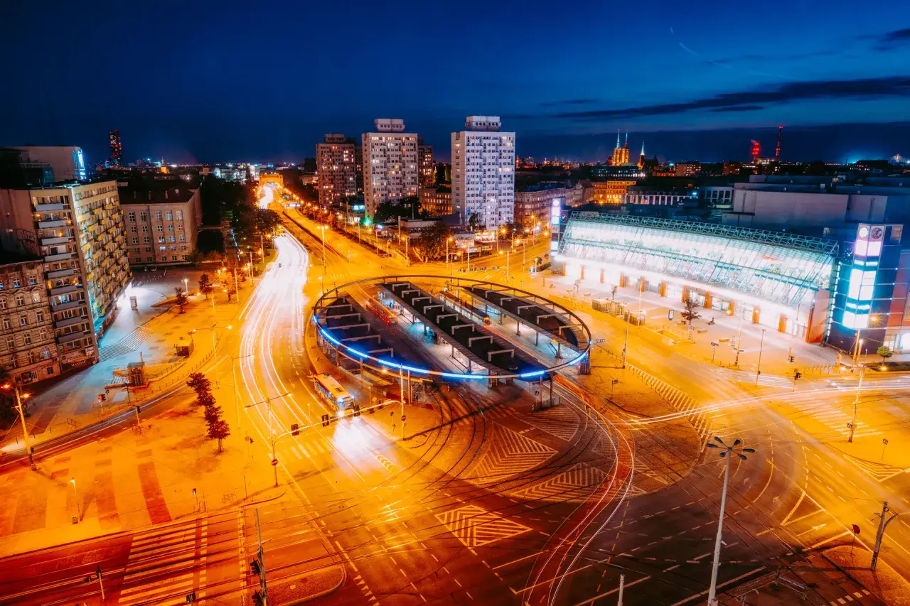 Nocne miasto z widokiem na pętlę tramwajową i dworzec, uchwycone obiektywem kitowym.