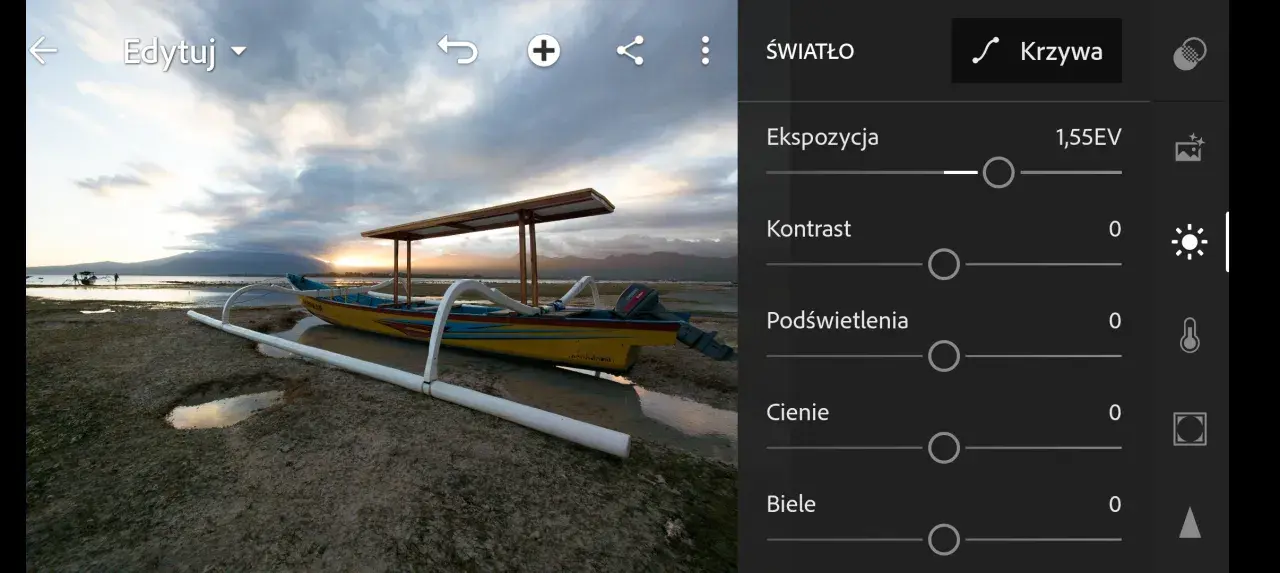Łódź na plaży podczas zachodu słońca, w trakcie obróbki raw. Widoczne suwaki ekspozycji, kontrastu, podświetleń, cieni i bieli.