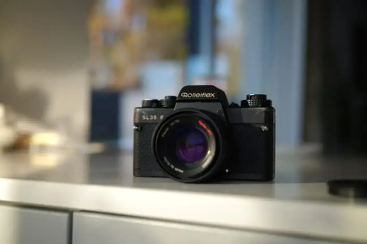 Klasyczny aparat Rolleiflex SL35 E, jeden z wielu wspaniałych przykładów zdjec analogowych, stoi na blacie.