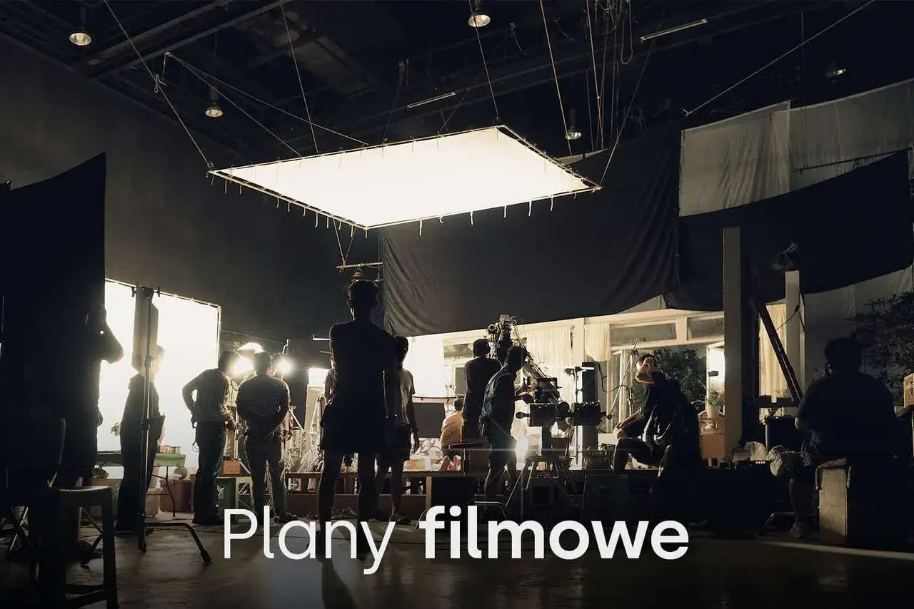 Ekipa filmowa przygotowuje scenę. Różne rodzaje oświetlenia i kamery tworzą atmosferę planu filmowego.