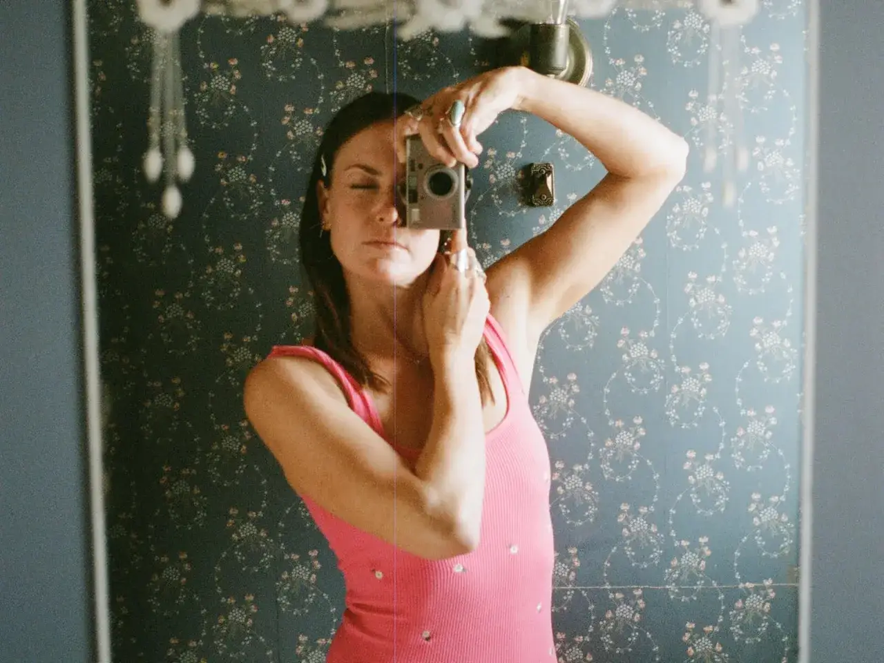 Magdalena Wosinska robi sobie selfie w łazience z aparatem w ręku.