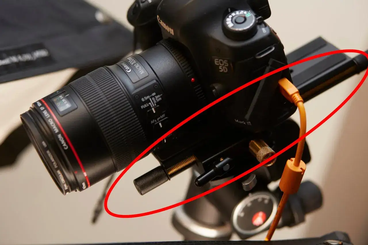 Aparat Canon EOS 5D Mark III z obiektywem makro 100mm, podłączony kablem. Sprzęt ustawiony na statywie, gotowy do pracy, być może do stackowania zdjęć.
