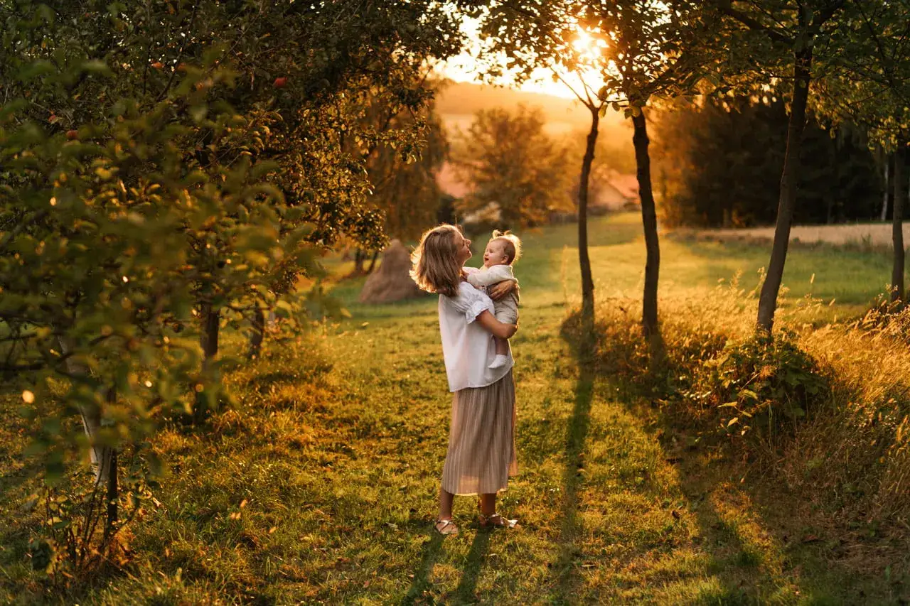 Piękna sesja lifestyle z mamą i dzieckiem w złotych promieniach zachodzącego słońca. Ciepło i miłość w naturalnym otoczeniu.