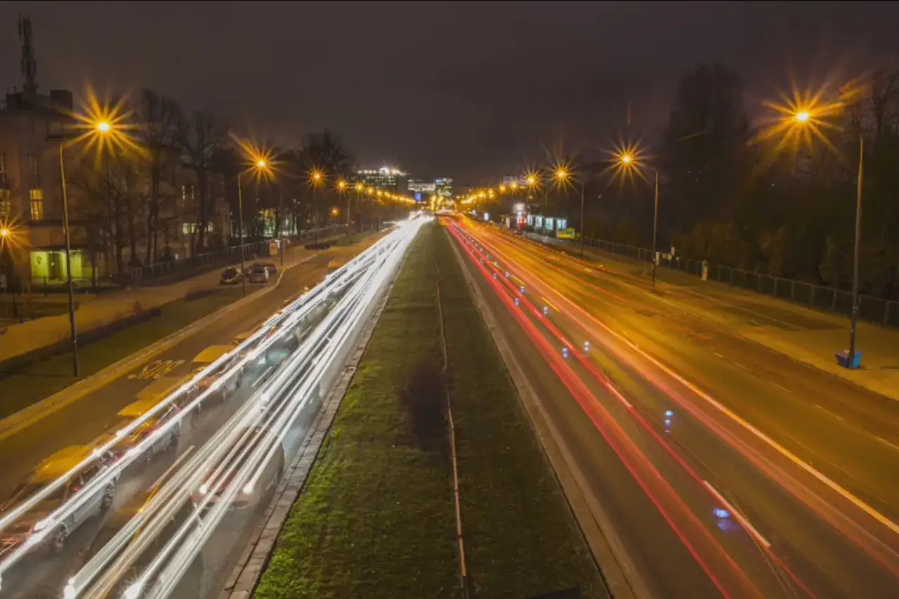 Nocne miasto rozświetlone światłami samochodów tworzącymi długie smugi.