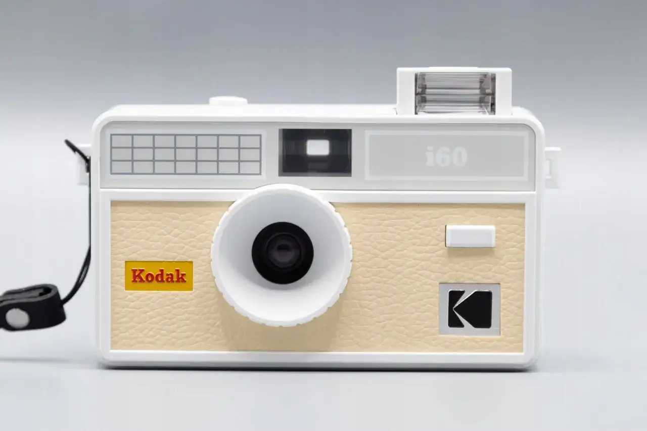 Biały aparat Kodak i60, pierwszy aparat małoobrazkowy, z beżową, skórzaną fakturą i charakterystycznym logo.
