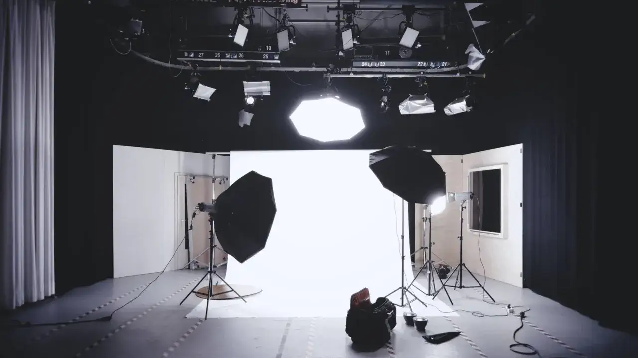 Profesjonalne studio fotograficzne z lampami, softboxami i białym tłem. Idealne miejsce, by dowiedzieć się, jaka lampa do zdjęć w domu sprawdzi się najlepiej.
