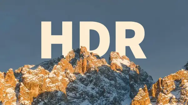 Zimowe szczyty górskie oświetlone słońcem, z napisem "HDR" na niebie.