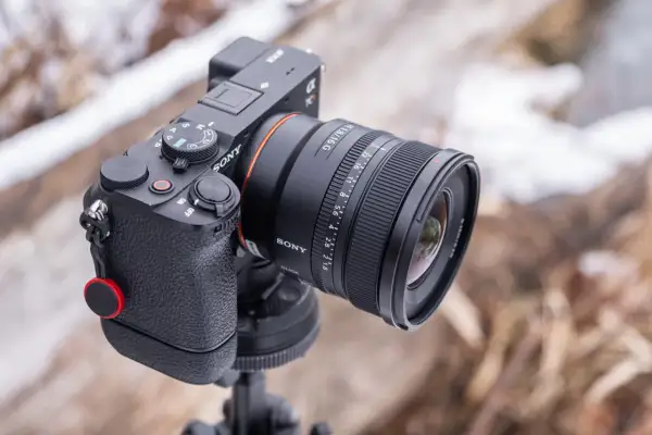 Aparat Sony z obiektywem 16mm f/1.8, idealny do krajobrazu. Ustawiony na statywie, gotowy do uchwycenia zimowego pejzażu.