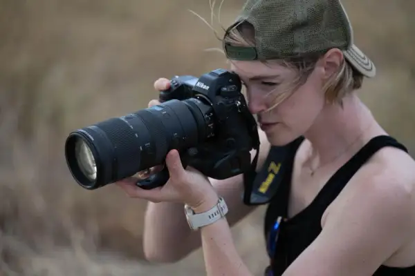 Kobieta w czapce z daszkiem celuje obiektywem aparatu Nikon Z, gotowa uchwycić chwilę. Czy to jej rywal Nikon?