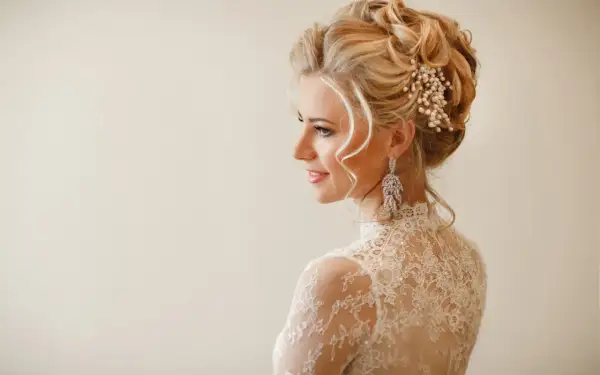 Eleganckie upięcia ślubne z perłami i kryształami, podkreślające urodę panny młodej w koronkowej sukni.